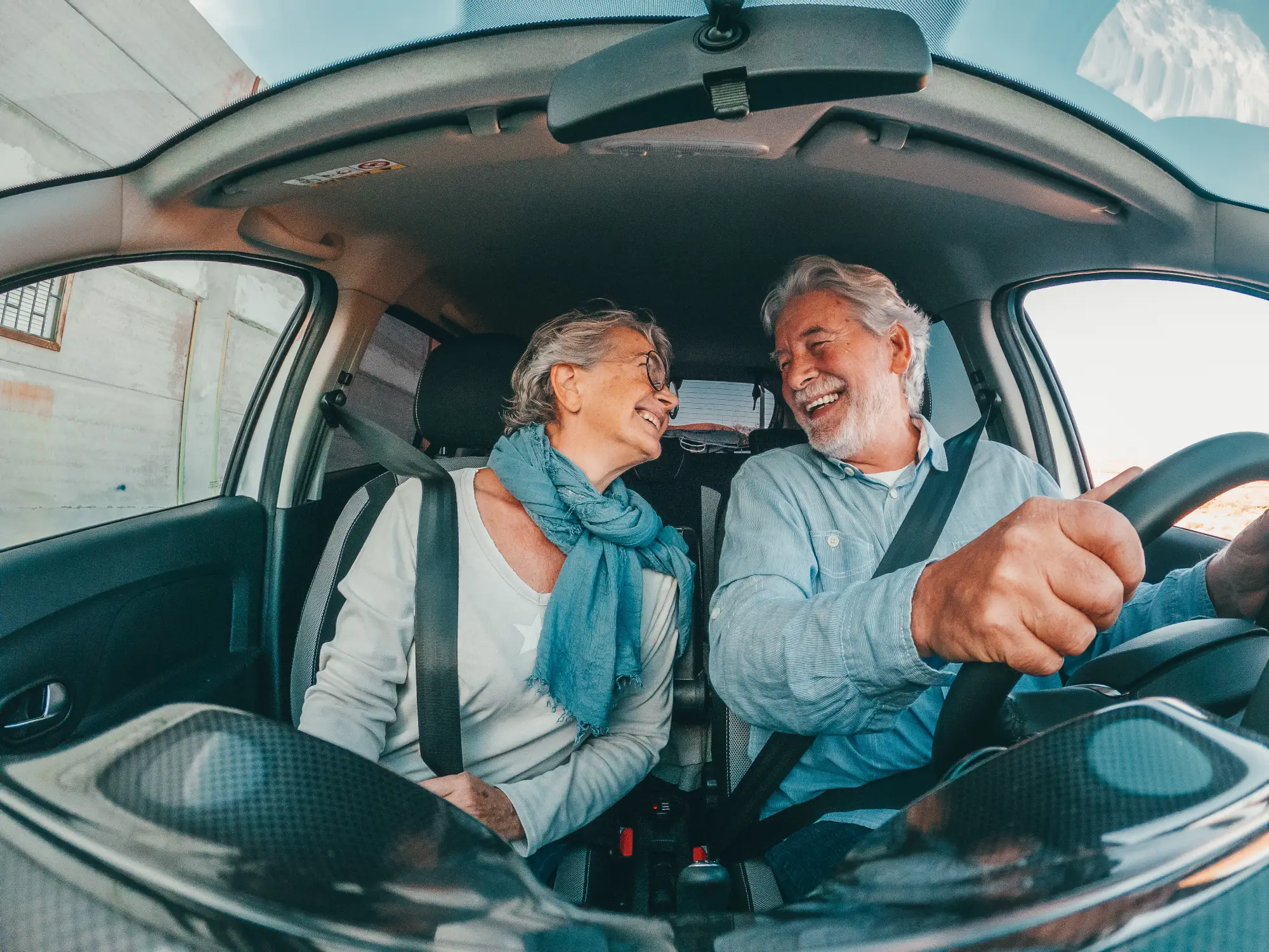 old couple having a good time while driving